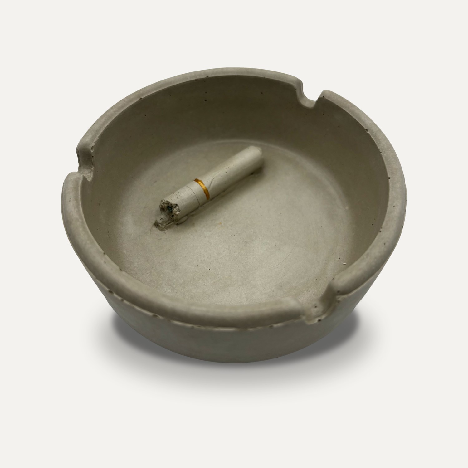 The concrete ashtray with its cast cigarette, after the wax has burned away
